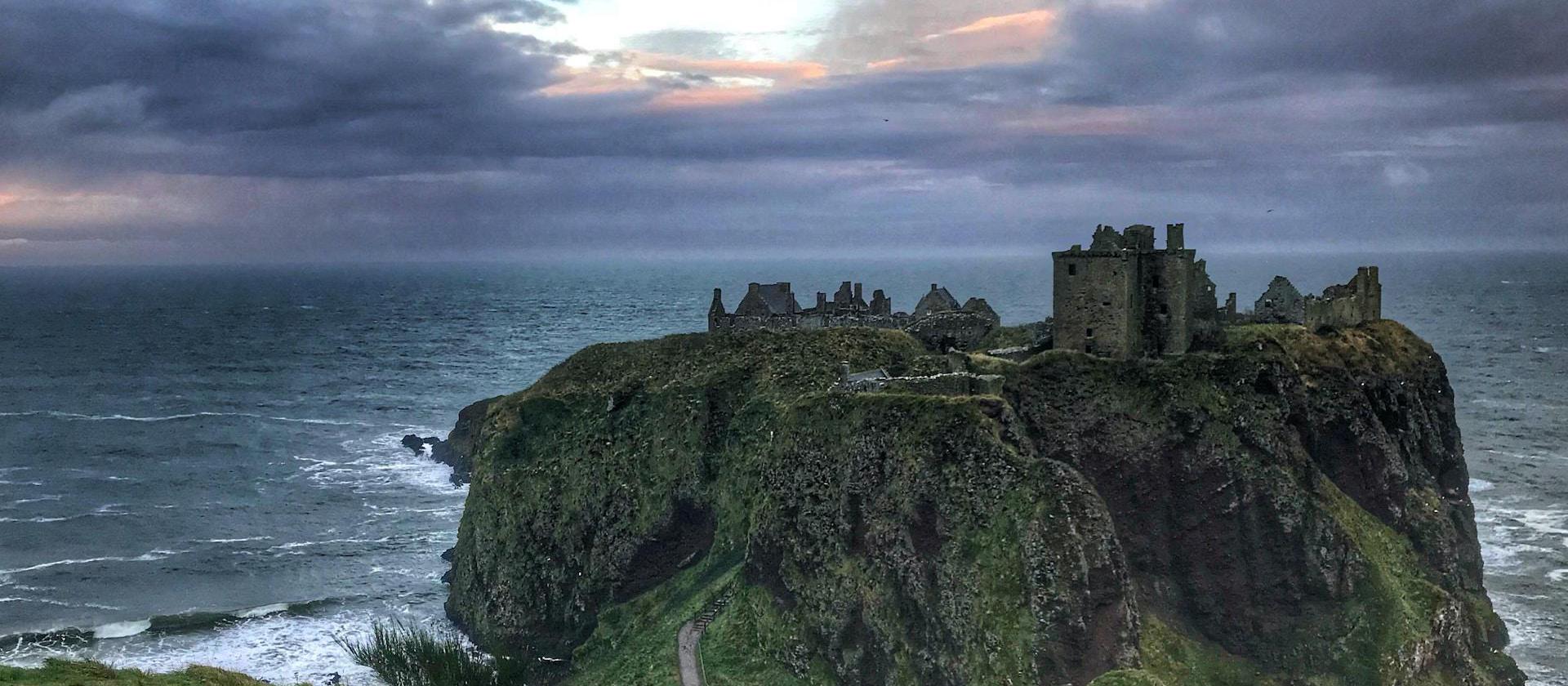 landscape photo of castle on top of mountain peak