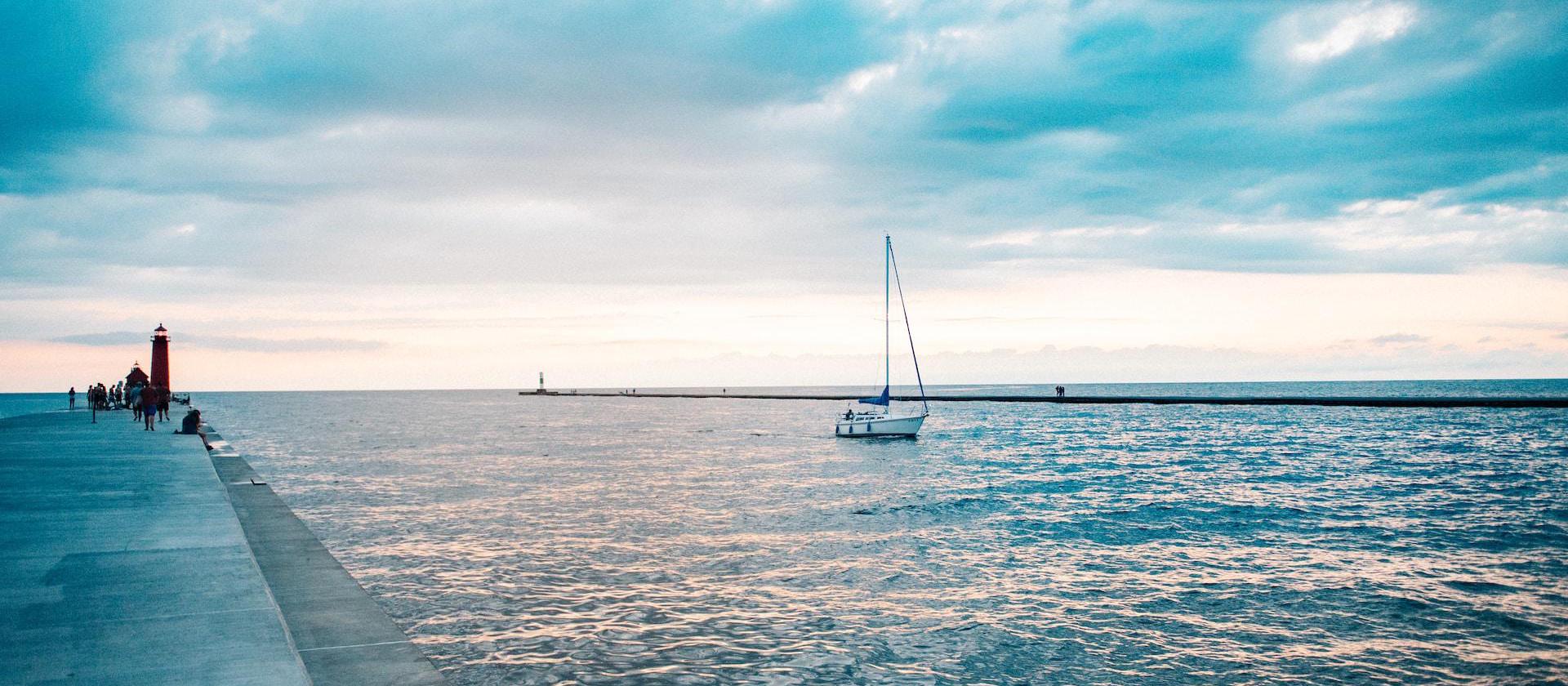 a sailboat is in the water near a pier