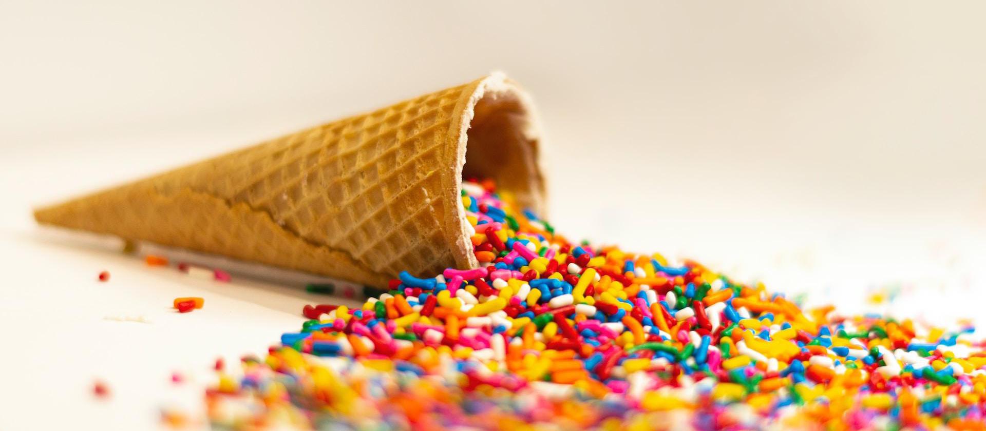 an ice cream cone filled with sprinkles and colored sprinkles
